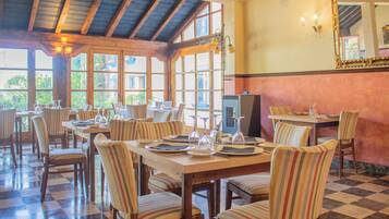 Un restaurante con suelo a cuadros, sillas a rayas y mesas de madera dispuestas para comer.