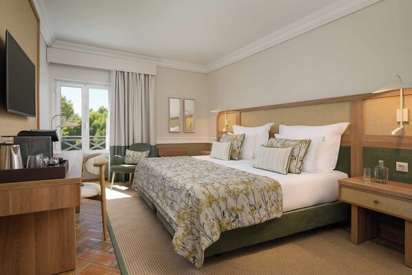 A hotel room with a bed, a desk, a chair, a TV, and a window with curtains. - M'AR De AR Muralhas (Évora)