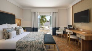 Una habitación de hotel con cama, escritorio, silla y televisión.