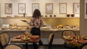A restaurant with a buffet setup, including various food items and utensils on display. - Hotel Bailli de Suffren (Paris)