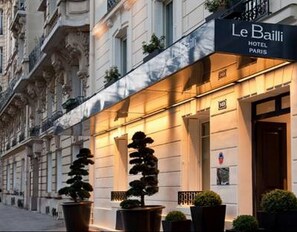 El exterior del Hotel Le Bailli en París, con una fachada clásica, ventanas amplias y una entrada destacada.