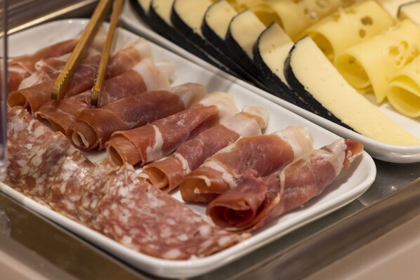 Una selección de embutidos y quesos en una bandeja.