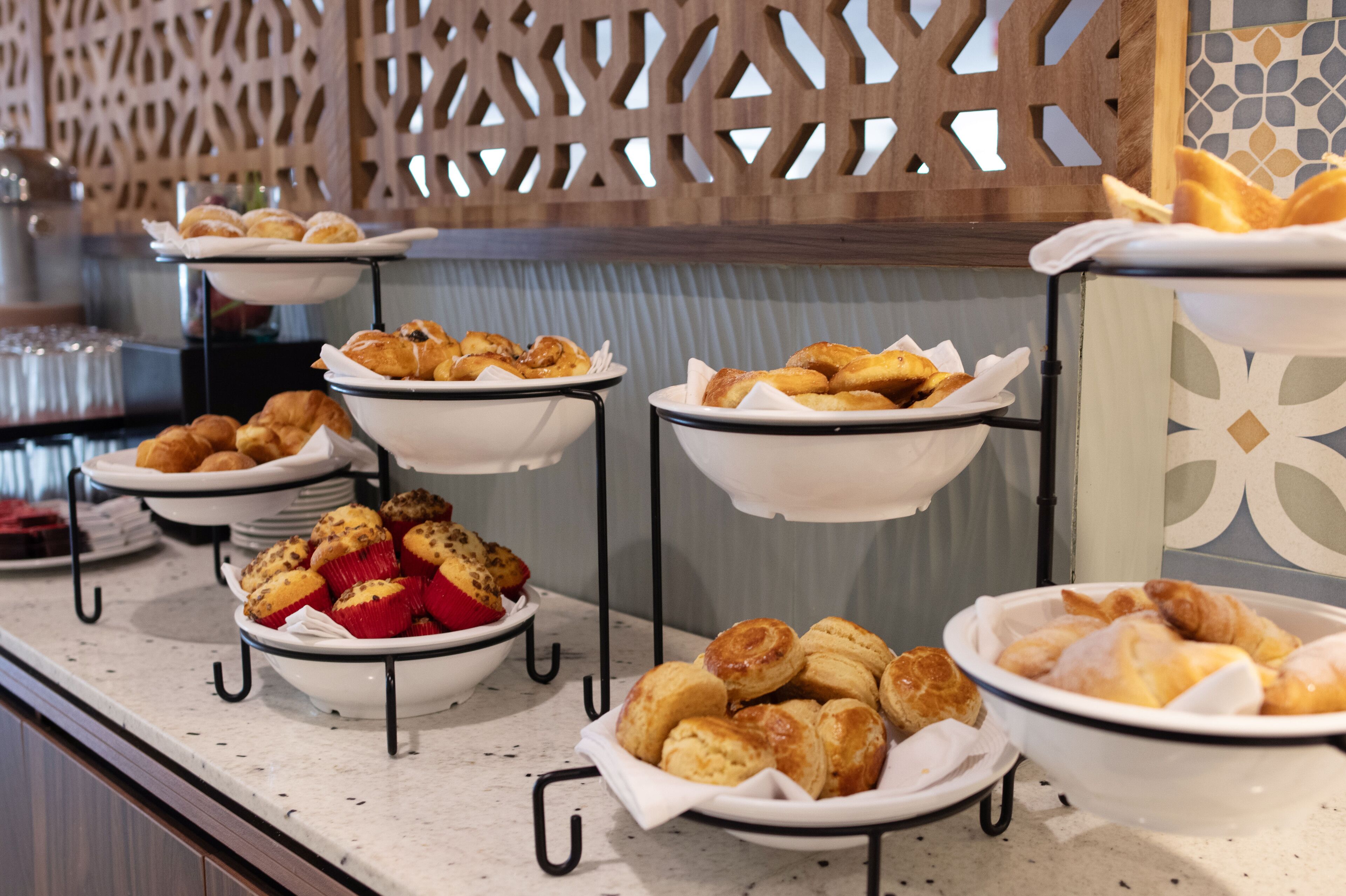 Un buffet proposant une variété de produits de boulangerie, notamment des pâtisseries et des muffins.