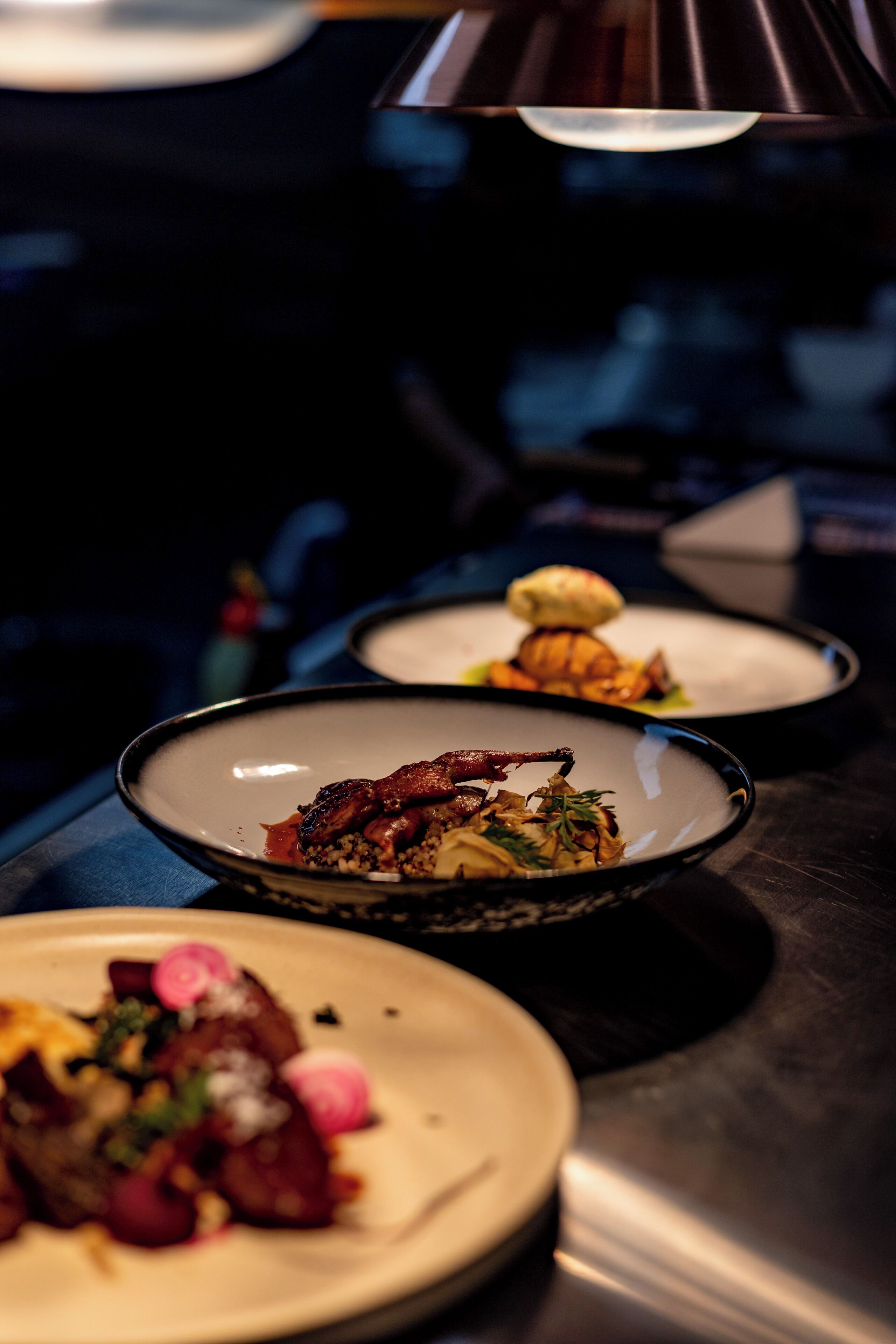 Flere tallerkener med forskellig mad, sandsynligvis på en restaurant.