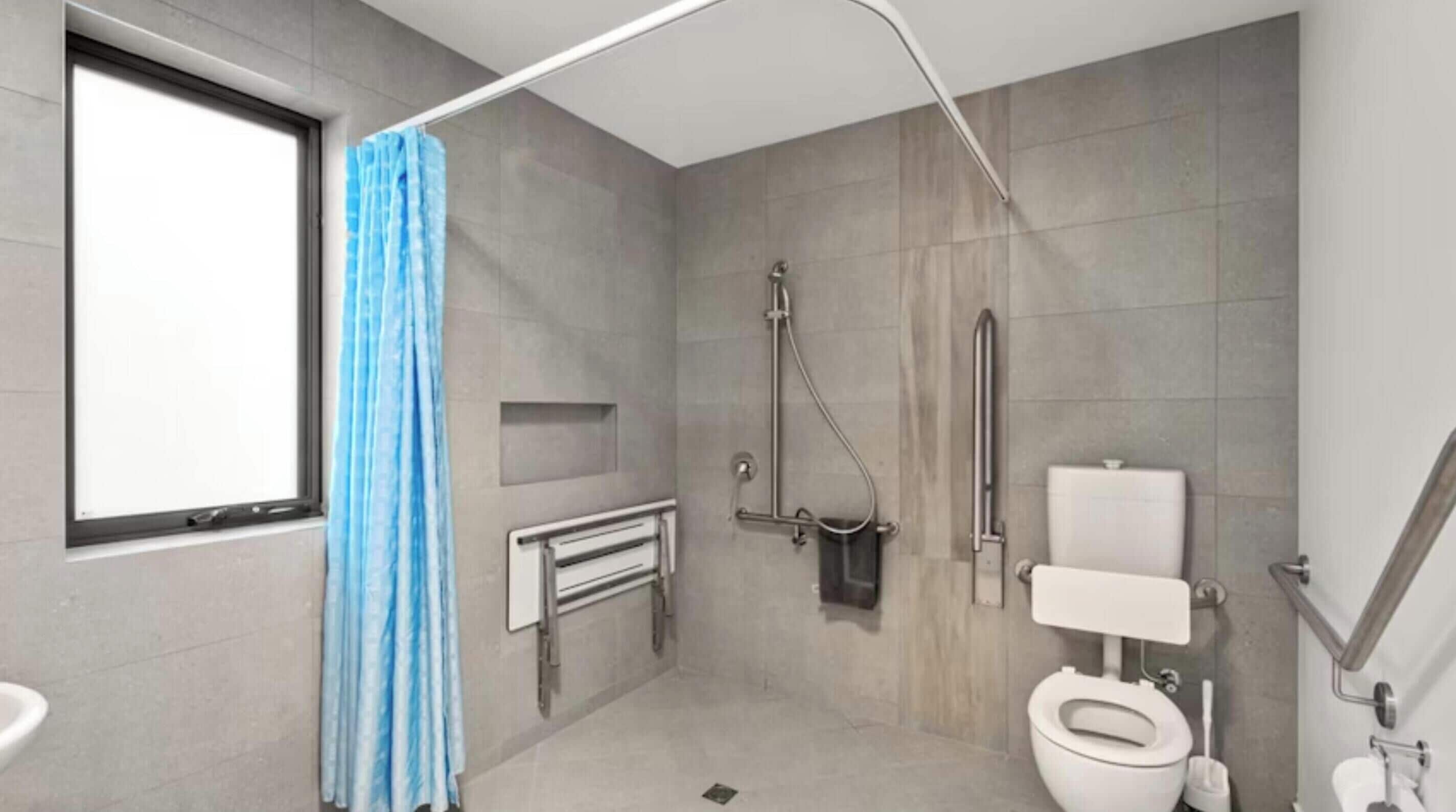 Un baño moderno con ducha, inodoro y ventana.