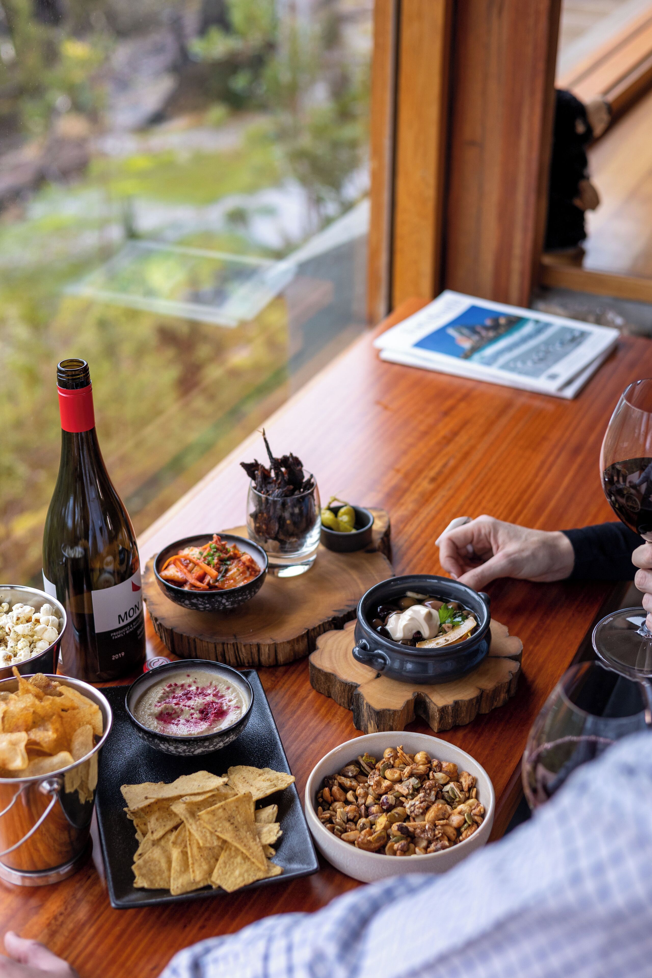 A dining table with various dishes, a bottle of wine, and a glass of wine.
