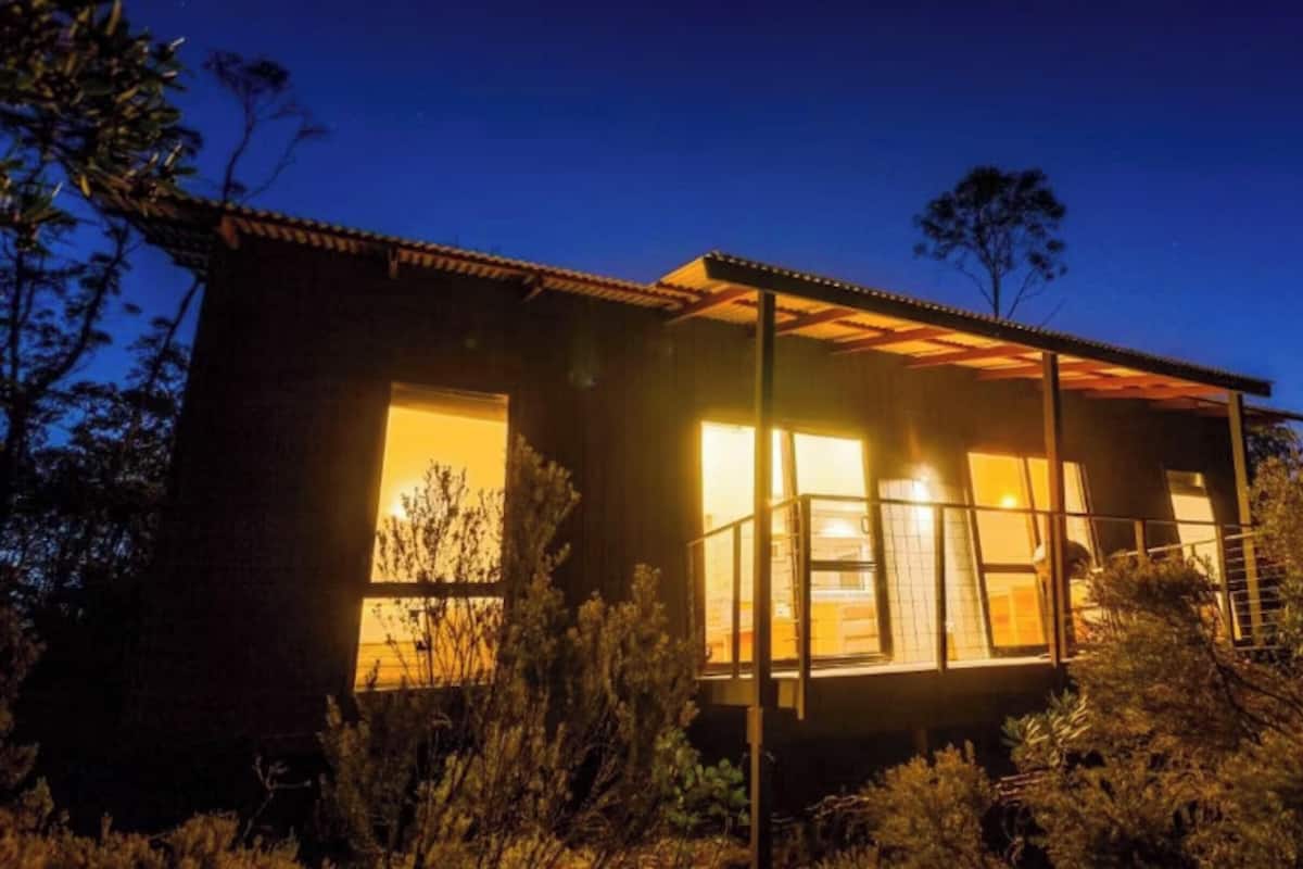 Eine Holzhütte mit großen Fenstern und einer Veranda.