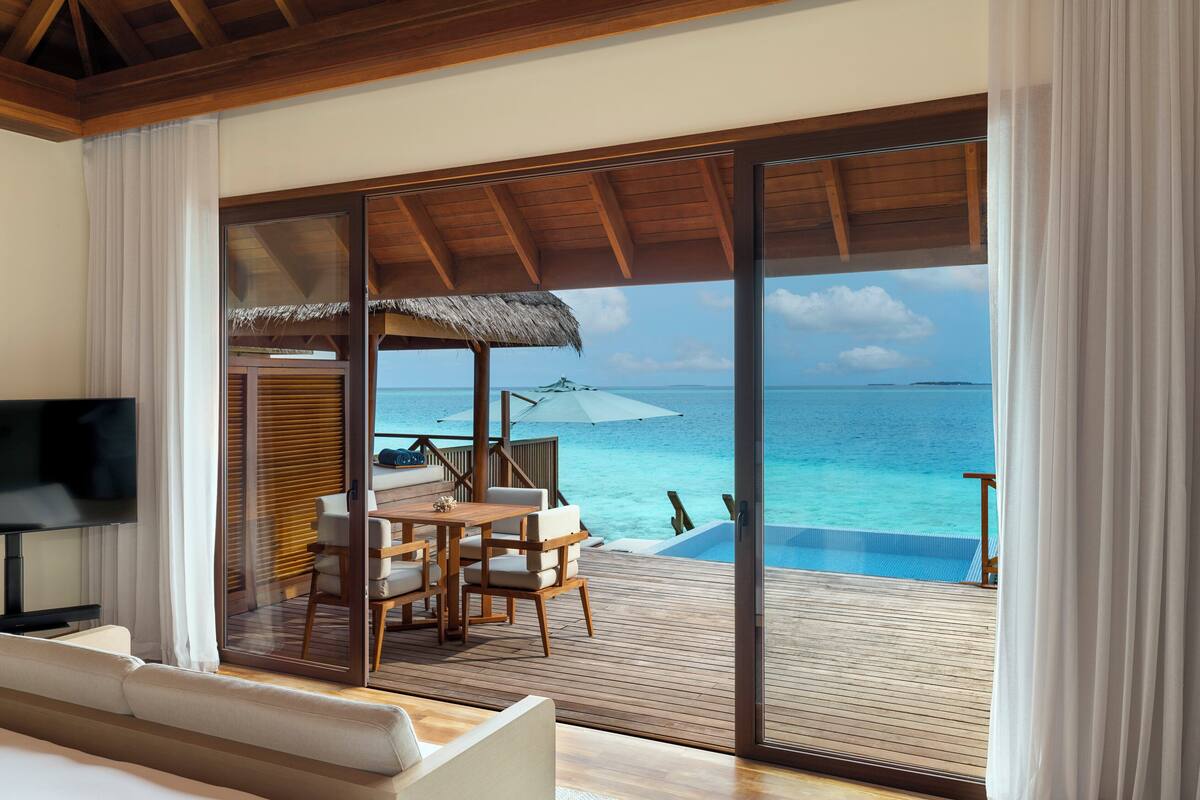 Ein Zimmer mit einer großen Glasschiebetür, die zu einem privaten Infinity-Pool und Meerblick führt.