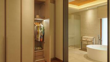 Une salle de bain moderne avec une grande baignoire, une douche à l’italienne et un plancher en bois.
