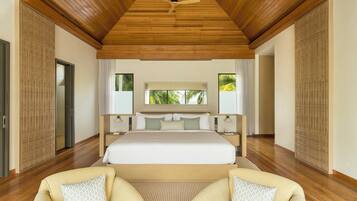 Un dormitorio amplio con una cama grande, techo de madera y vistas a palmeras a través de la ventana.