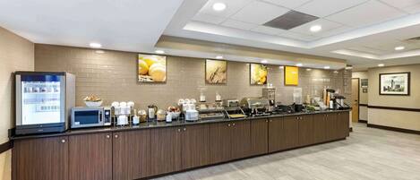 A breakfast bar with a refrigerator, microwave, and various food items.