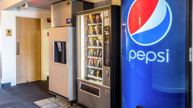 A vending machine with snacks and a Pepsi refrigerator in a hallway. - Motel 6 Great Falls, MT (Great Falls)