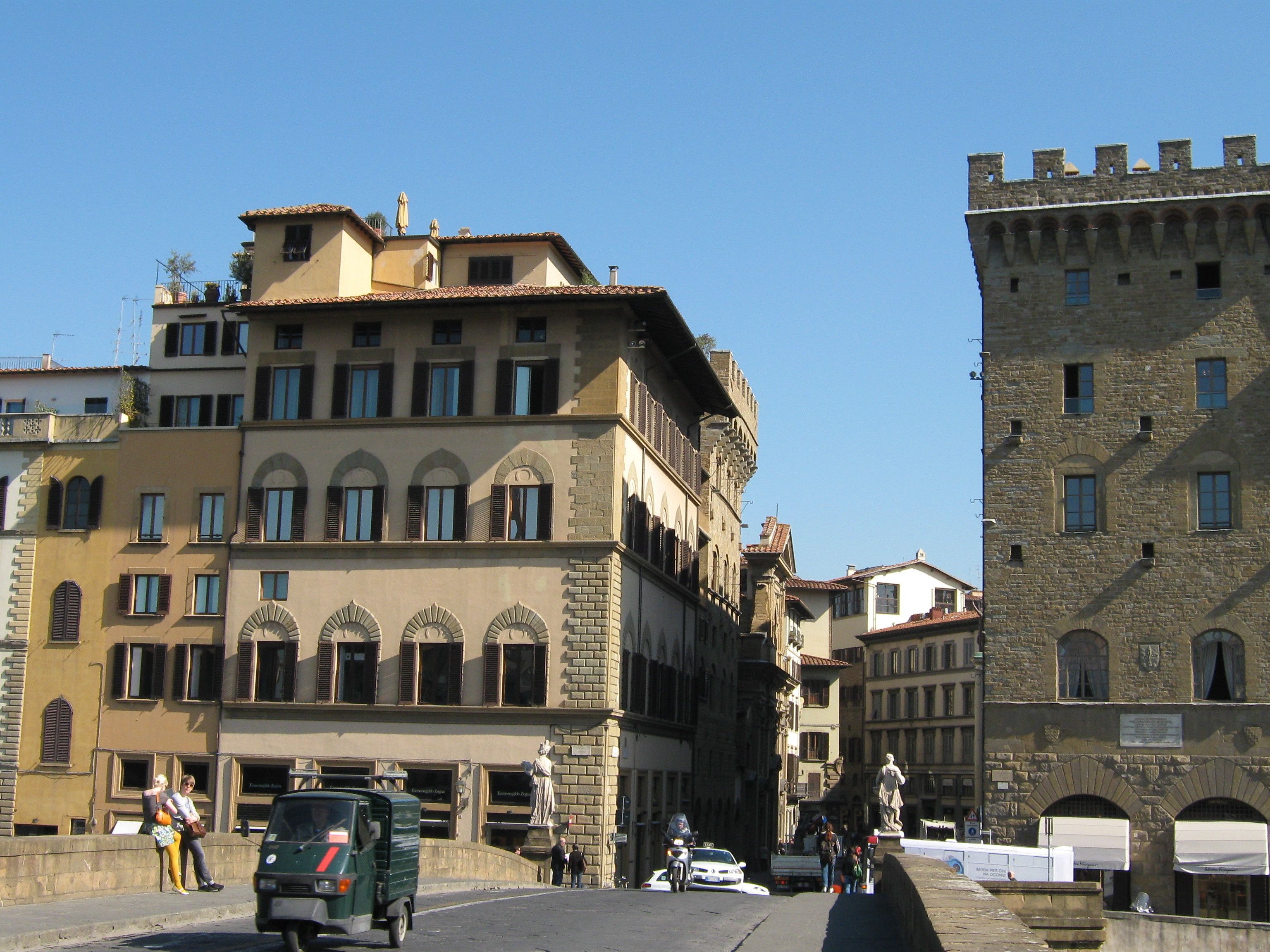 A historic building with multiple stories, arched windows, and a stone facade.