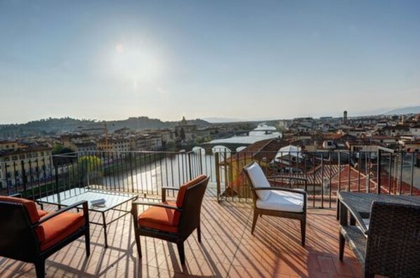 Une terrasse avec des sièges extérieurs et une vue sur le paysage urbain.