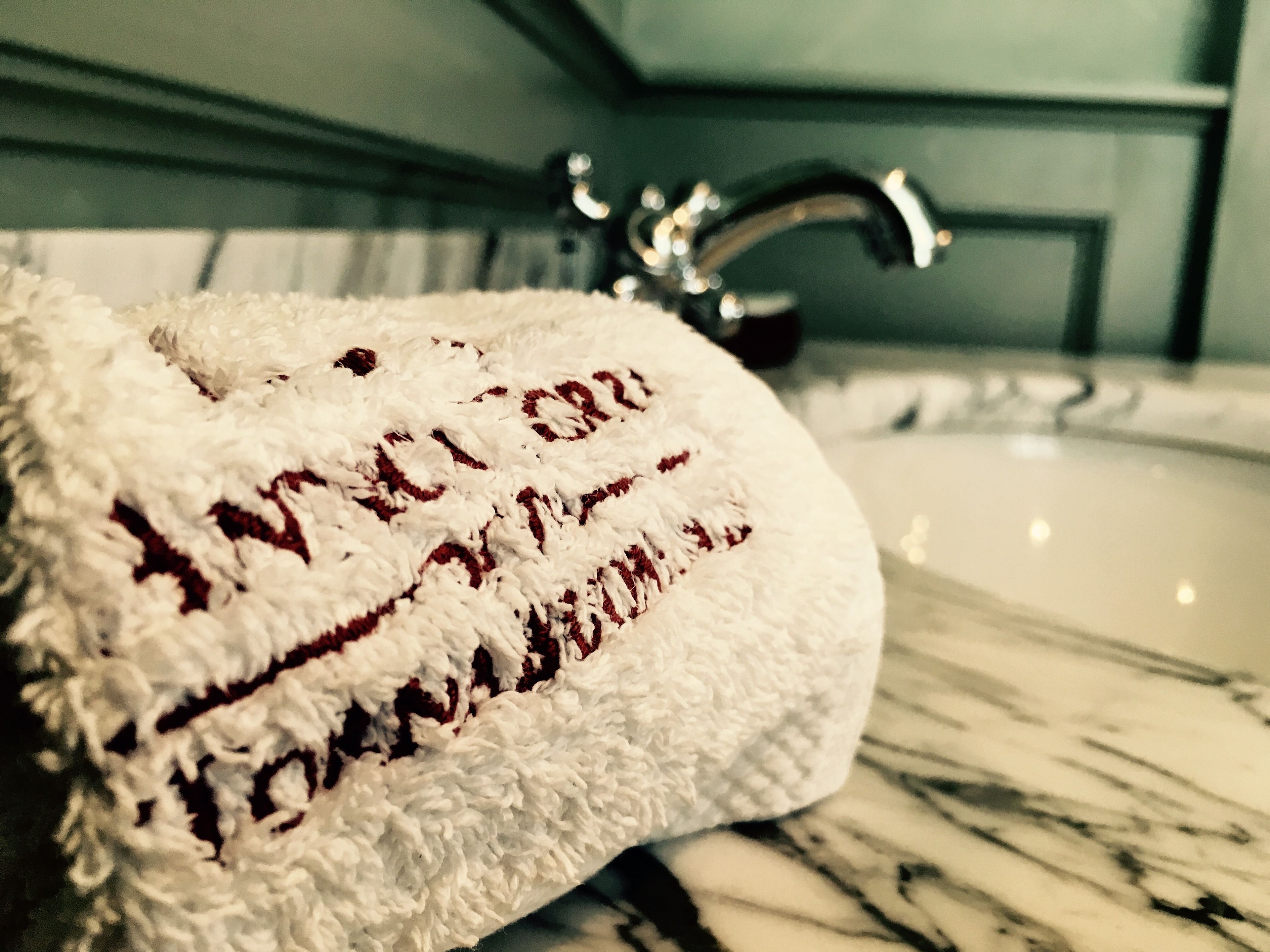 Um banheiro com uma toalha branca sobre uma pia de mármore.