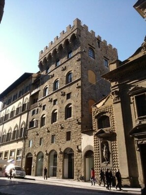 Un bâtiment historique doté d’une tour imposante et de fenêtres en arc de cercle.