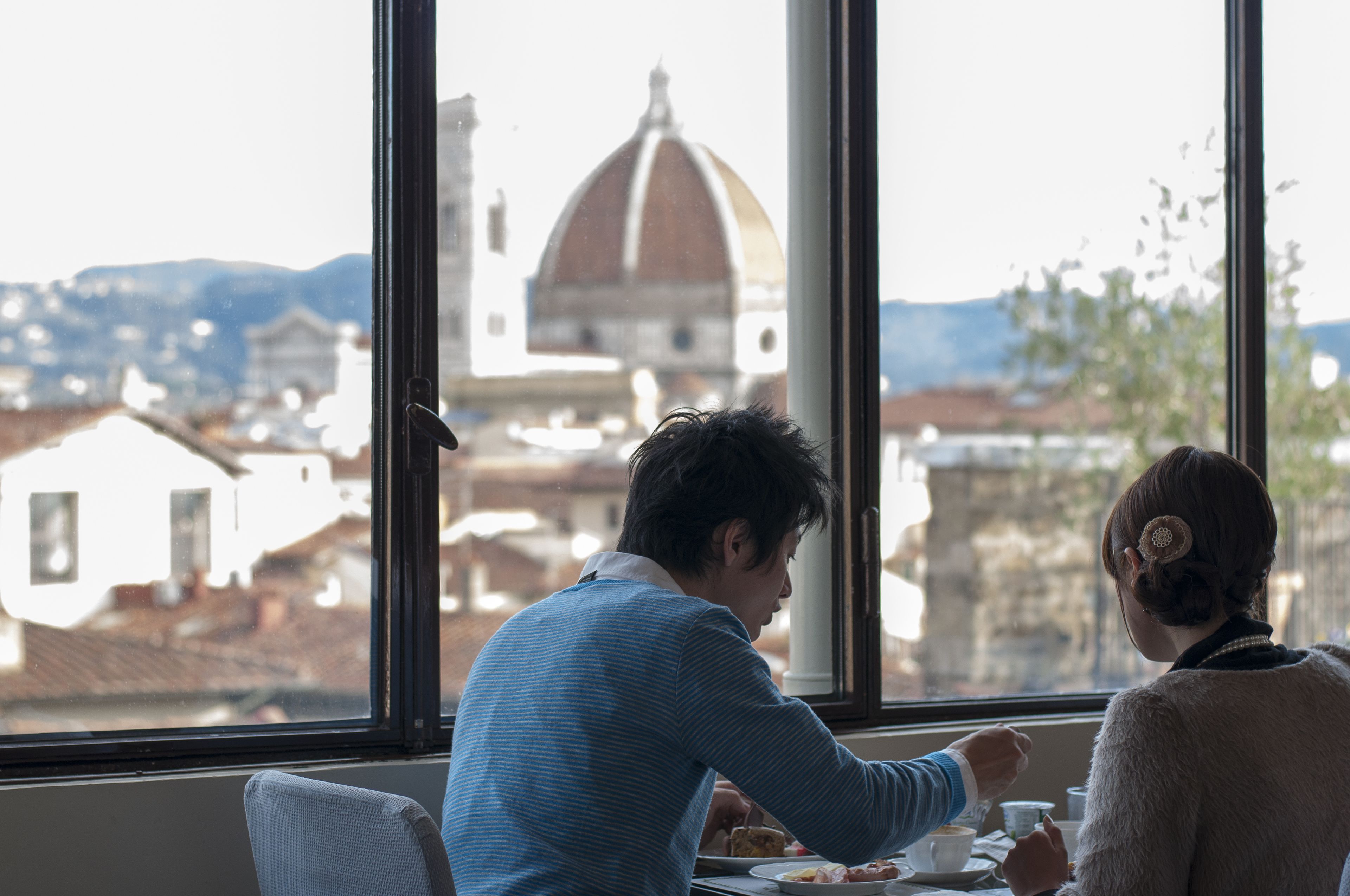 A room with a large window offering a view of a historic building with a dome.