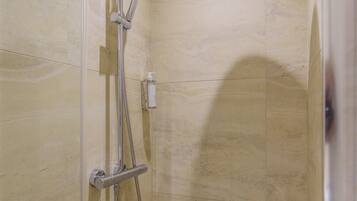 A shower with a handheld showerhead and a wall-mounted rain showerhead in a tiled room.