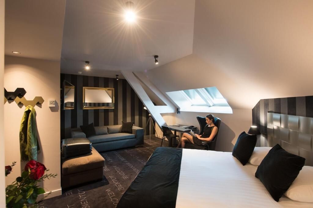Une chambre d’hôtel moderne équipée d’un lit, d’un bureau et d’un coin salon.