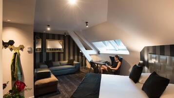 Une chambre d’hôtel moderne équipée d’un lit, d’un bureau et d’un coin salon.