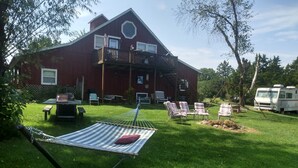 A red barn with a balcony, a hammock, and outdoor seating. - Kennedys Red Barn Inn (Perry)