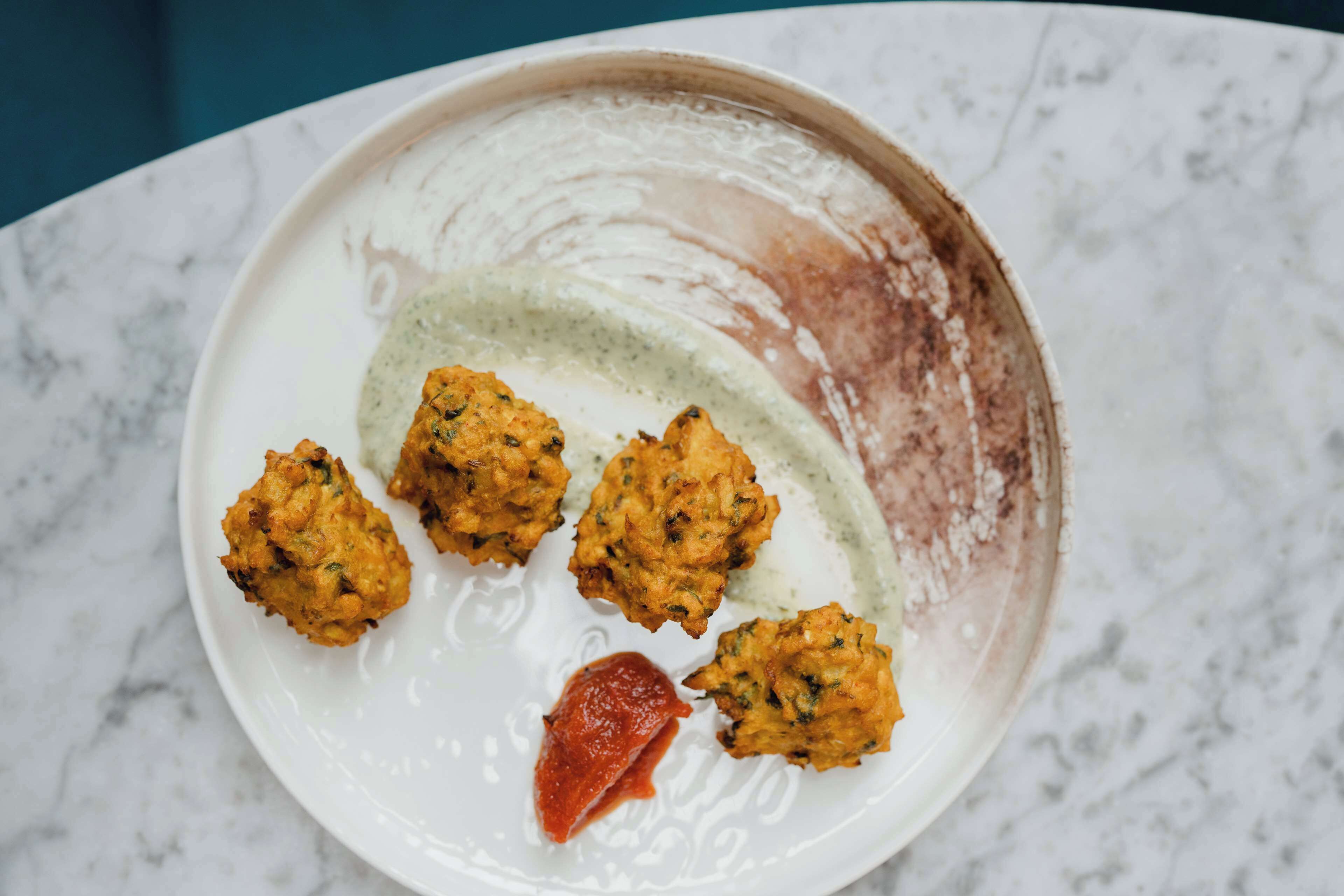 A plate with food items and a sauce.