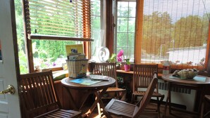 Una habitación con muebles de madera, una mesa con una cesta y una ventana con persianas.