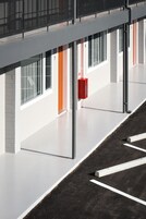Ένα σύγχρονο κτίριο με αριθμημένα δωμάτια, ένα κόκκινο κουτί συναγερμού πυρκαγιάς και ανεμπόδιστη θέα στον ουρανό.