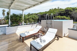 A rooftop terrace with two sun loungers, a small table with a drink, and a pool. - Savoy Hotel & Spa (Capaccio-Paestum)