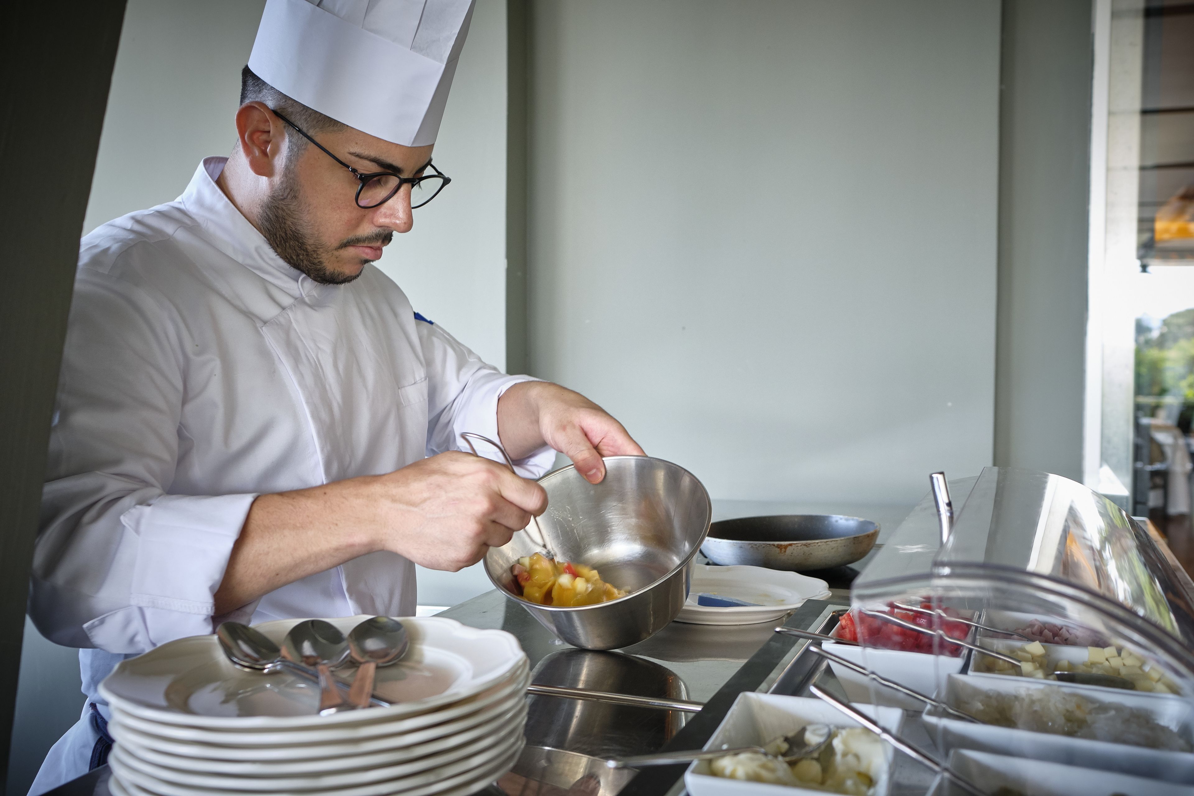 Un chef preparando comida en una cocina profesional.