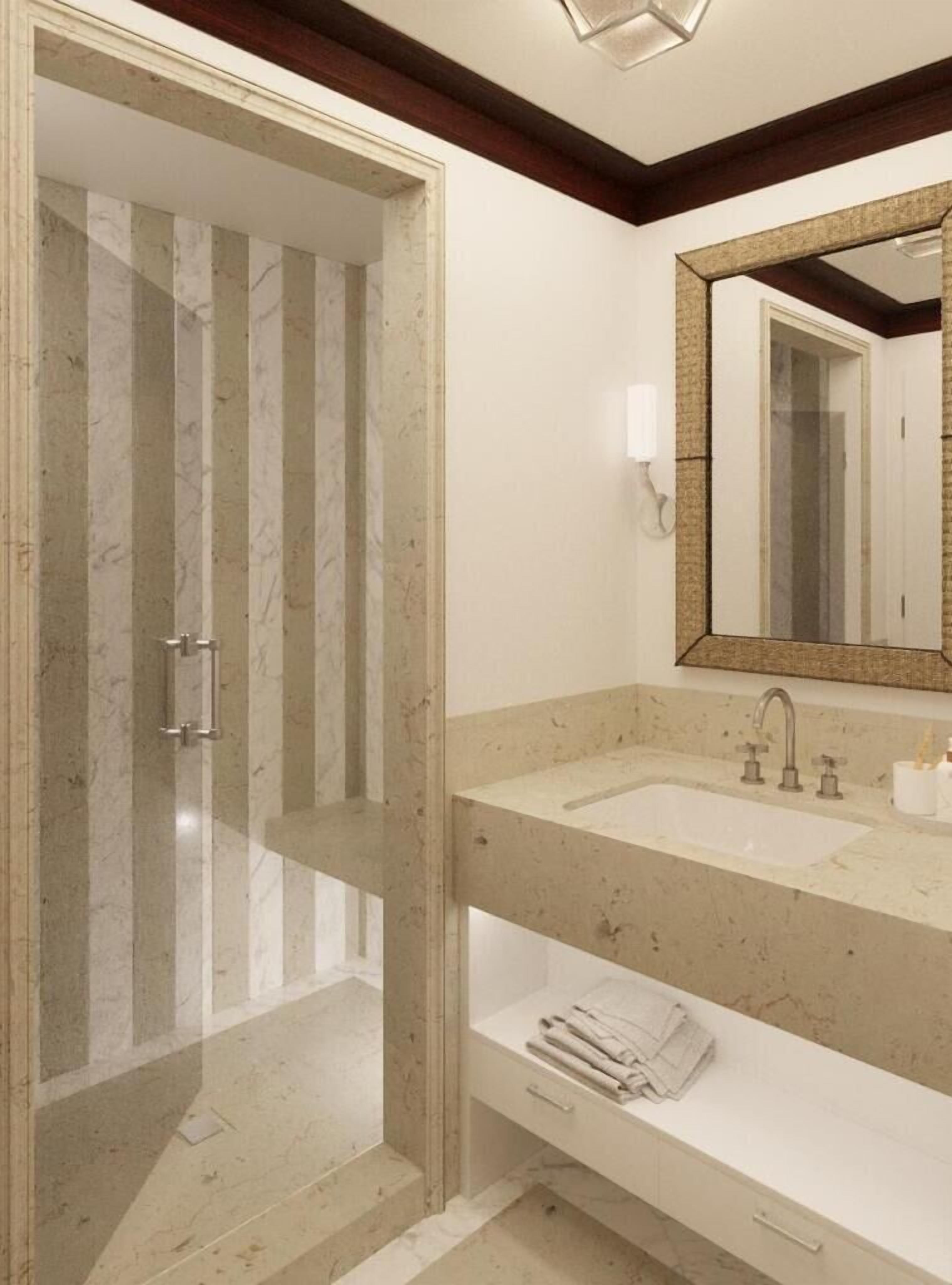A bathroom with a shower, two sinks, a mirror, and a towel rack.