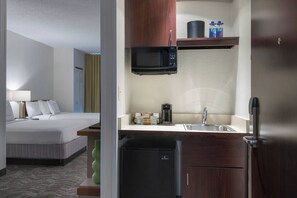 A hotel room with a bed, a small kitchenette with a microwave, a coffee maker, and a mini fridge. - Springhill Suites By Marriott - Danbury (Danbury)