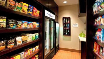 A snack aisle in a hotel with various packaged snacks and a refrigerated display.