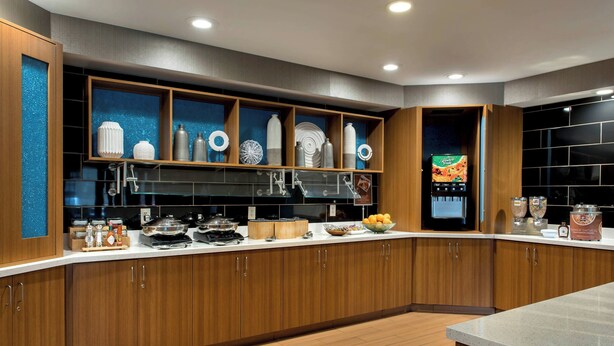A modern kitchen with wooden cabinets, a stainless steel backsplash, and various kitchen appliances. - Springhill Suites By Marriott - Danbury (Danbury)