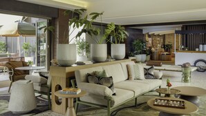 Una sala de estar moderna con un sofá, una mesa de centro y plantas en macetas.