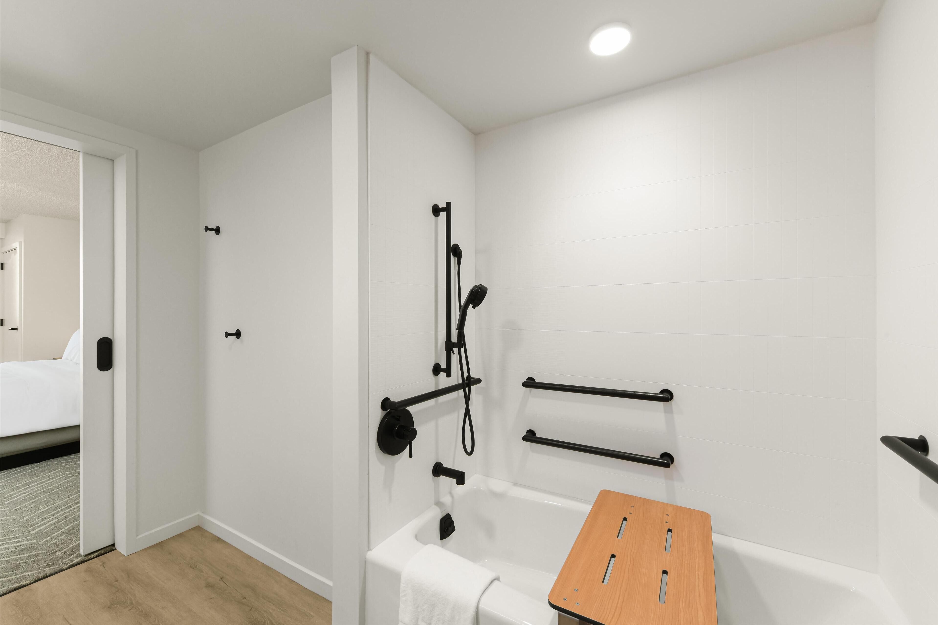 Ein modernes Badezimmer mit Badewanne, Duschkopf und Handtuchhalter.