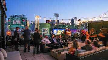 An outdoor seating area with wicker furniture and a view of Fenway Park.
