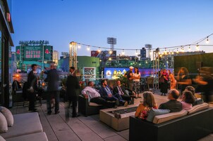 Zona salotto esterna con mobili in vimini e vista sul Fenway Park.