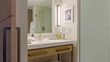 A modern bathroom with a glass shower enclosure, a vanity with a mirror, and a towel rack.