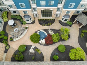An aerial view of a courtyard with a central water feature, surrounded by landscaped areas and seating. - Staybridge Suites Columbus-Dublin by IHG (Dublin)