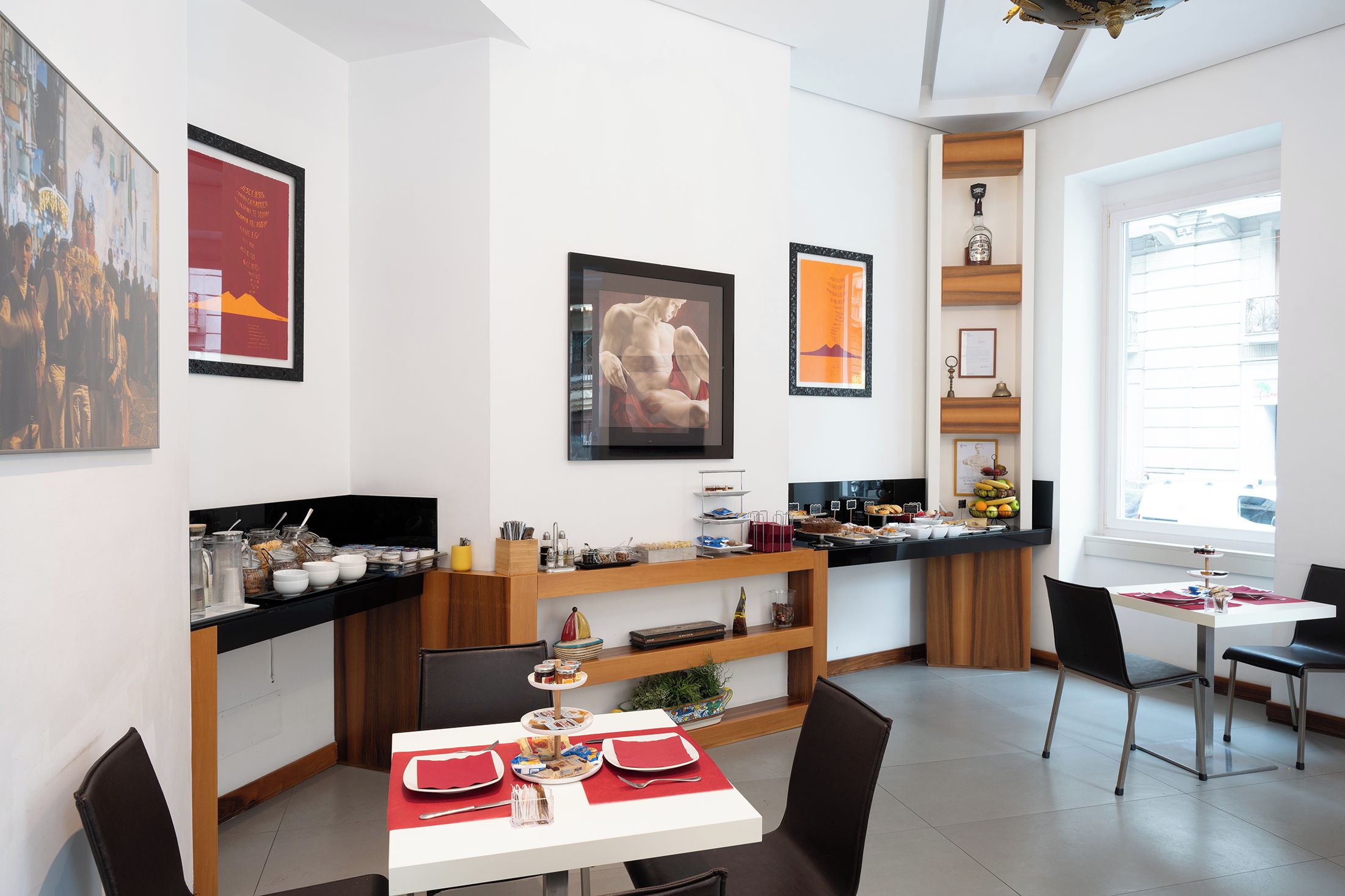 A modern dining area with a white table, black chairs, and a red table runner.