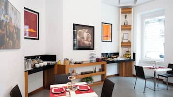 A modern dining area with a white table, black chairs, and a red table runner.