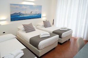 A hotel room with two beds, a painting of a ship on the wall, and a view of the sea. - Rex Lifestyle Hotel (Naples)