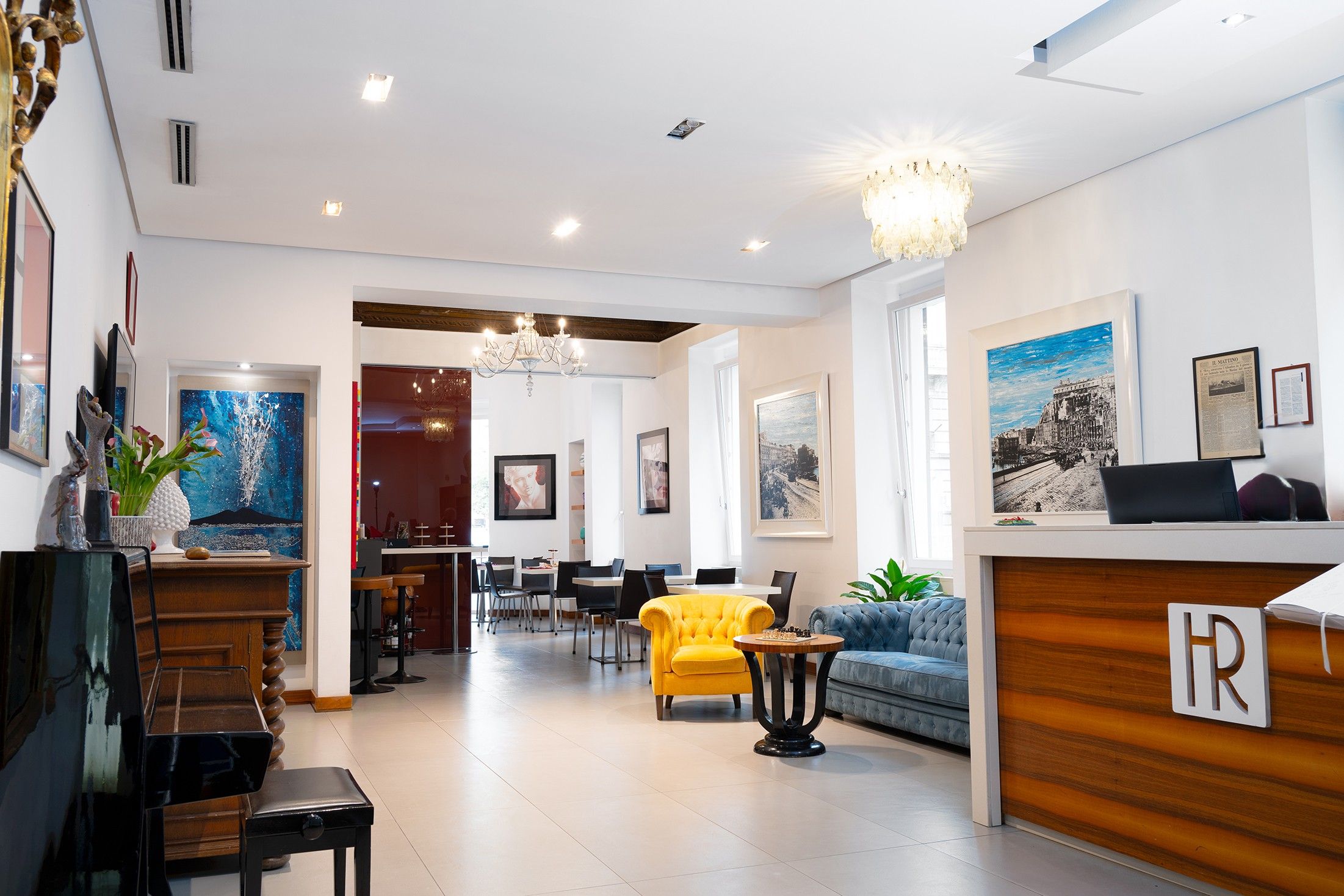 Eine Hotelhalle mit Empfangstresen, Sitzgelegenheiten und Kunstwerken an den Wänden.