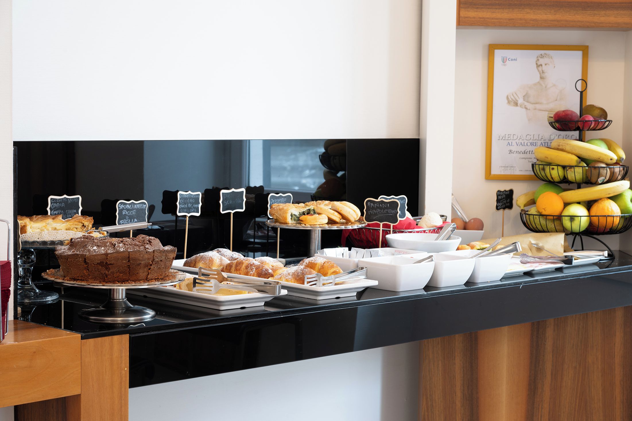 A buffet counter with various food items and labels.