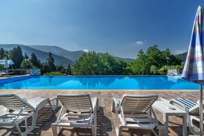 Seasonal outdoor pool, an infinity pool, pool umbrellas, sun loungers