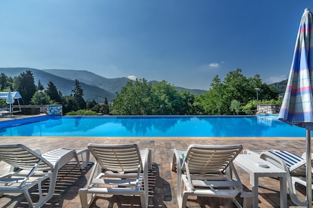 Una piscina al aire libre de temporada, una piscina infinita, sombrillas