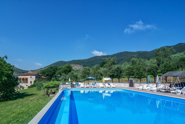 Seasonal outdoor pool, an infinity pool, pool umbrellas, pool loungers