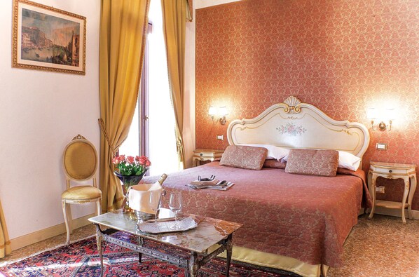 Une chambre à coucher bien rangée, avec un lit, des tables de chevet, une chaise et une table sur laquelle se trouvent un verre et une bouteille.