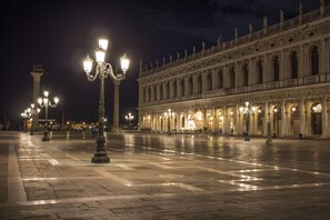 Une place publique, agrémentée de réverbères décoratifs et dominée par un imposant bâtiment à l’architecture classique.